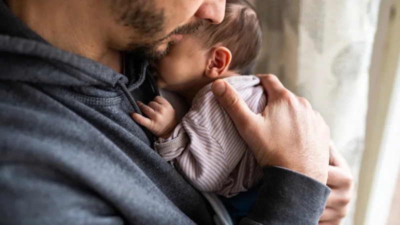 Mann mit kleinem Baby auf dem Arm