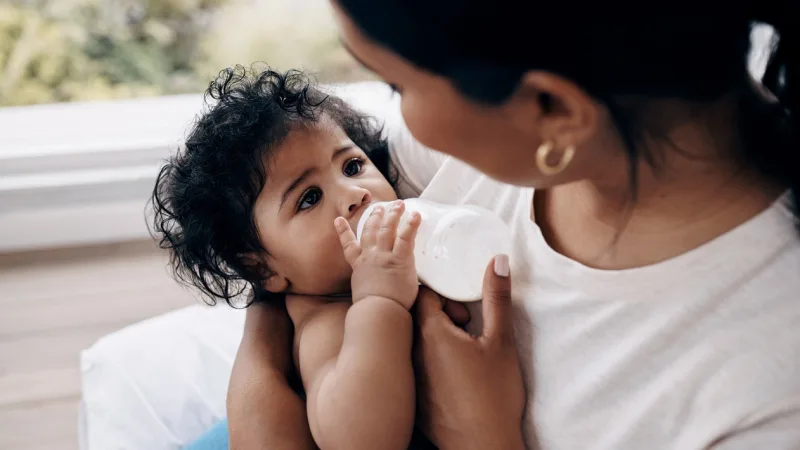 Frau gibt einem Baby die Flasche